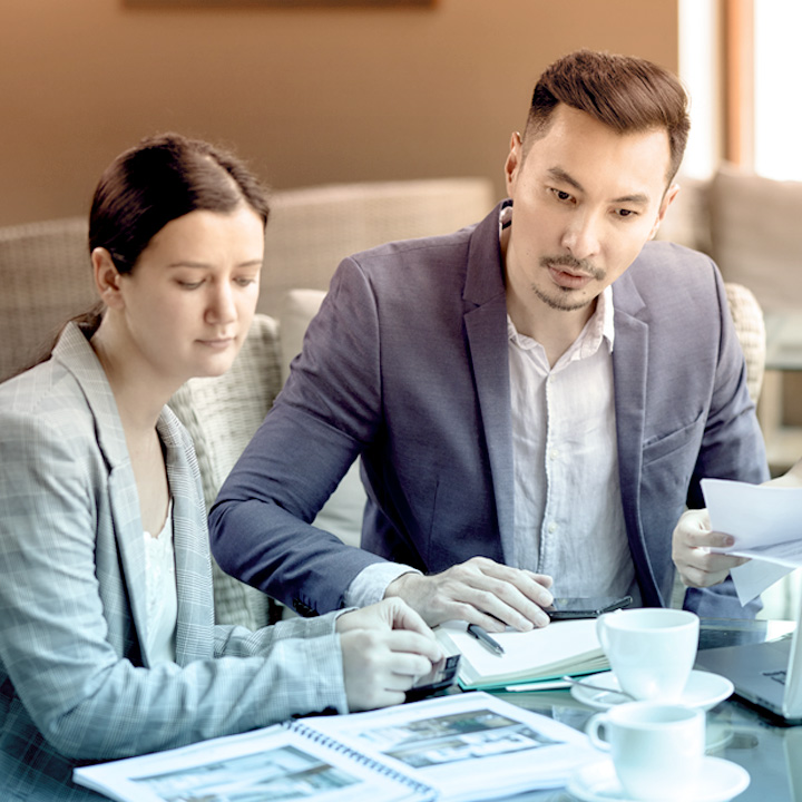 Photo of group of people looking at documents on table