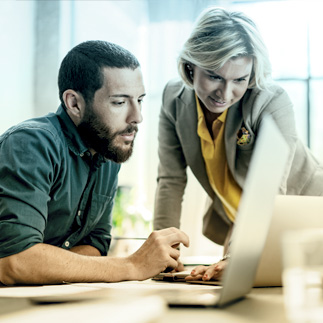 Photo of two people looking at laptop