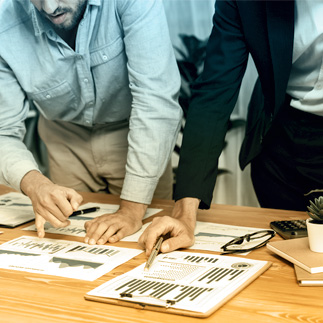 Photo of people standing at table looking at documents