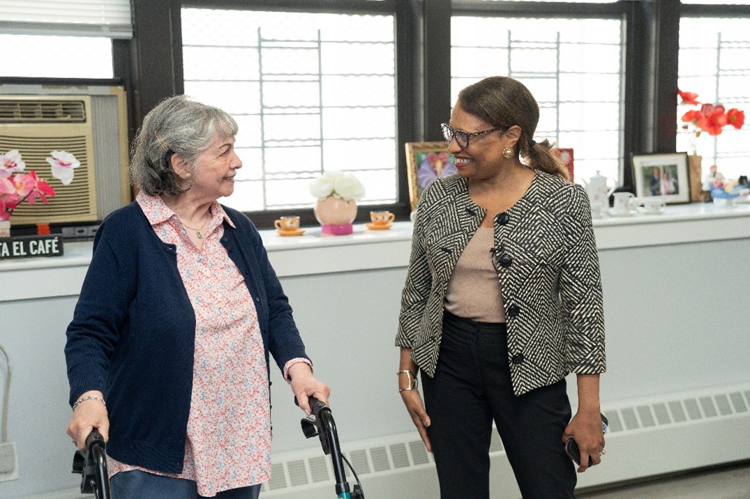 [In photo: Acting Secretary Adrianne Todman engaging with resident]