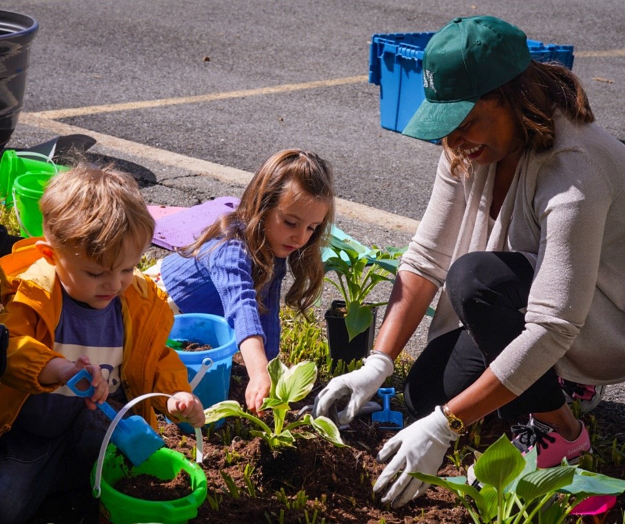 Acting Secretary Adrianne Todman interacting with children during planting event