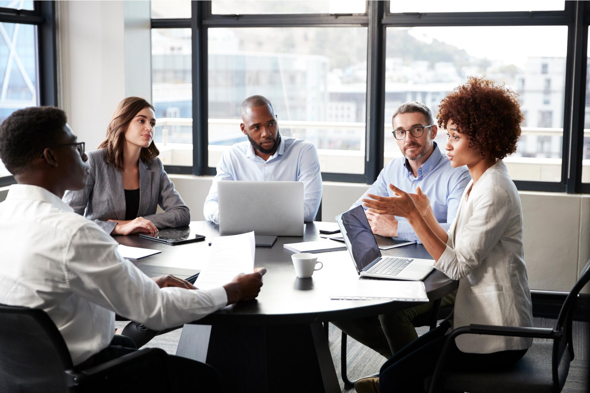 A group of people around a table having a discussion